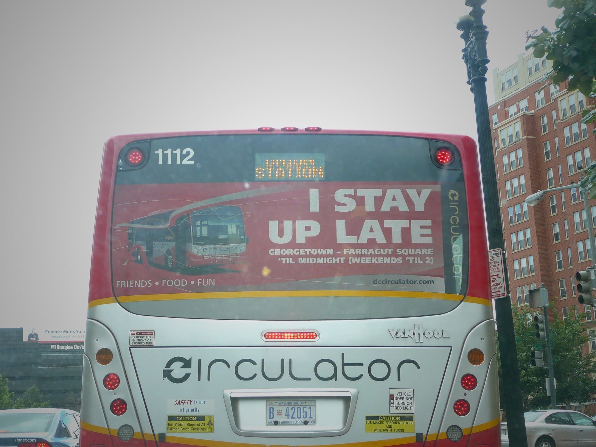 A picture of the D.C. circulator with a sign on the back that reads "I stay up late."