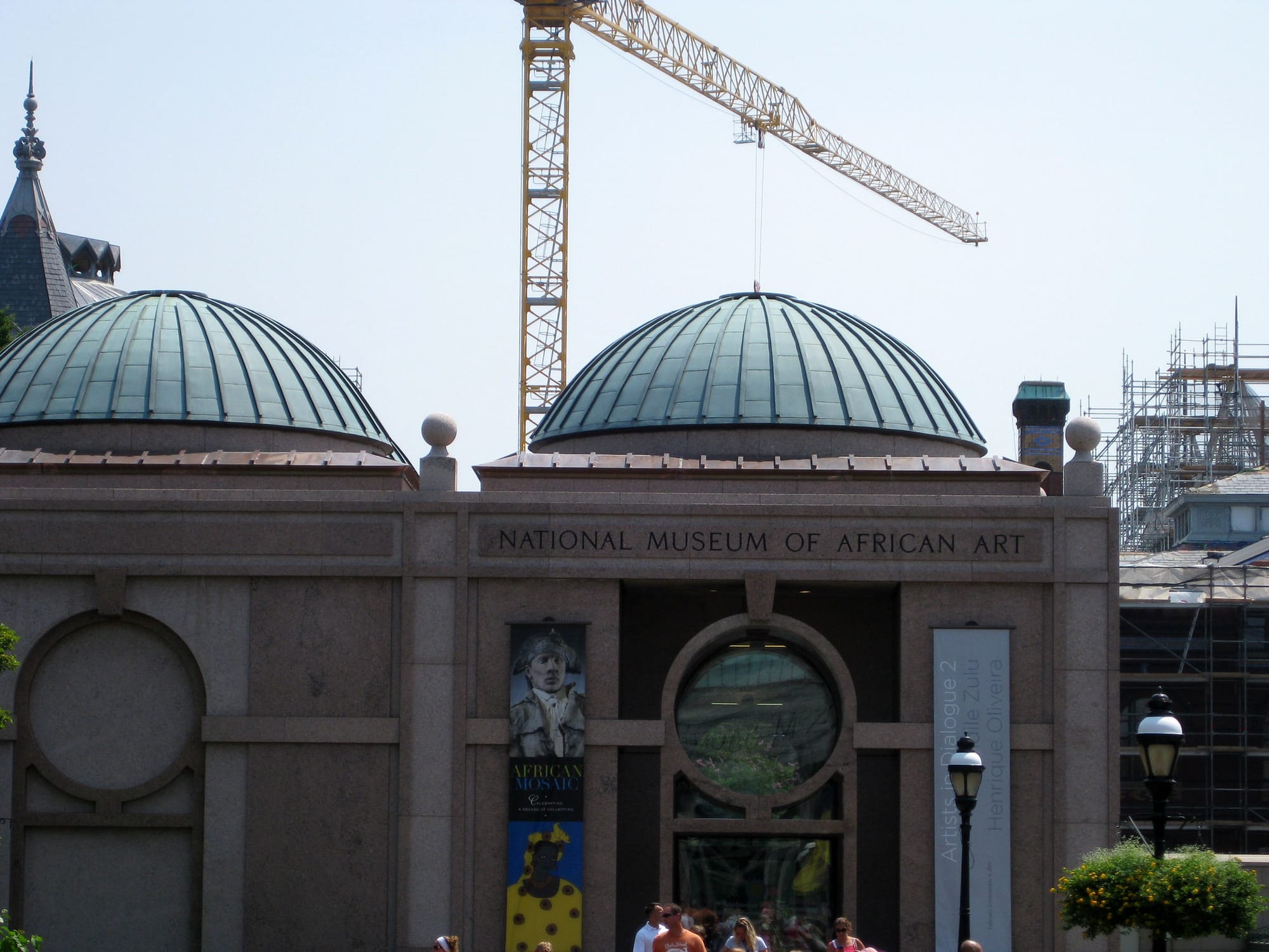 A photo of the outside of the National Museum of African Art with a crane in the background.