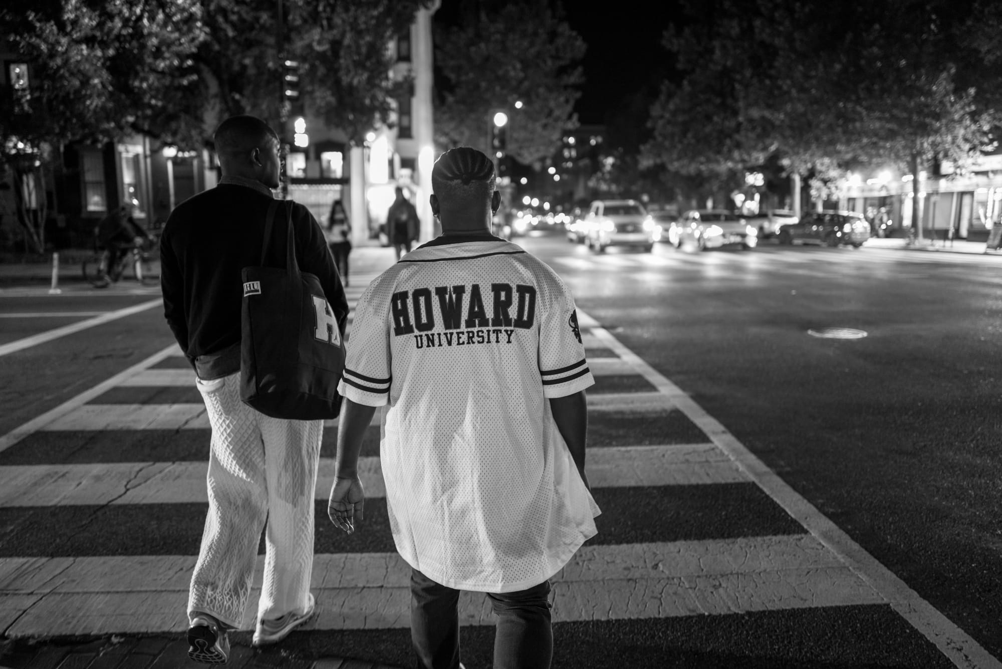 Two young people facing away from the camera walk down Washington D.C.'s U Street.