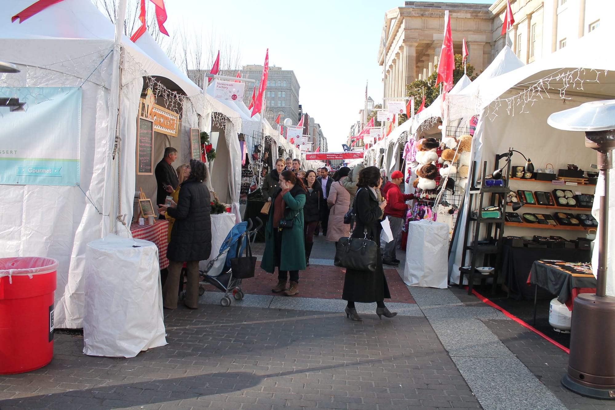 A crowd of shoppers peruses white-tent stalls on a brick street in downtown D.C. 