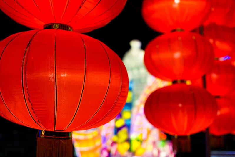 Large red lanterns hover against a dark backdrop.