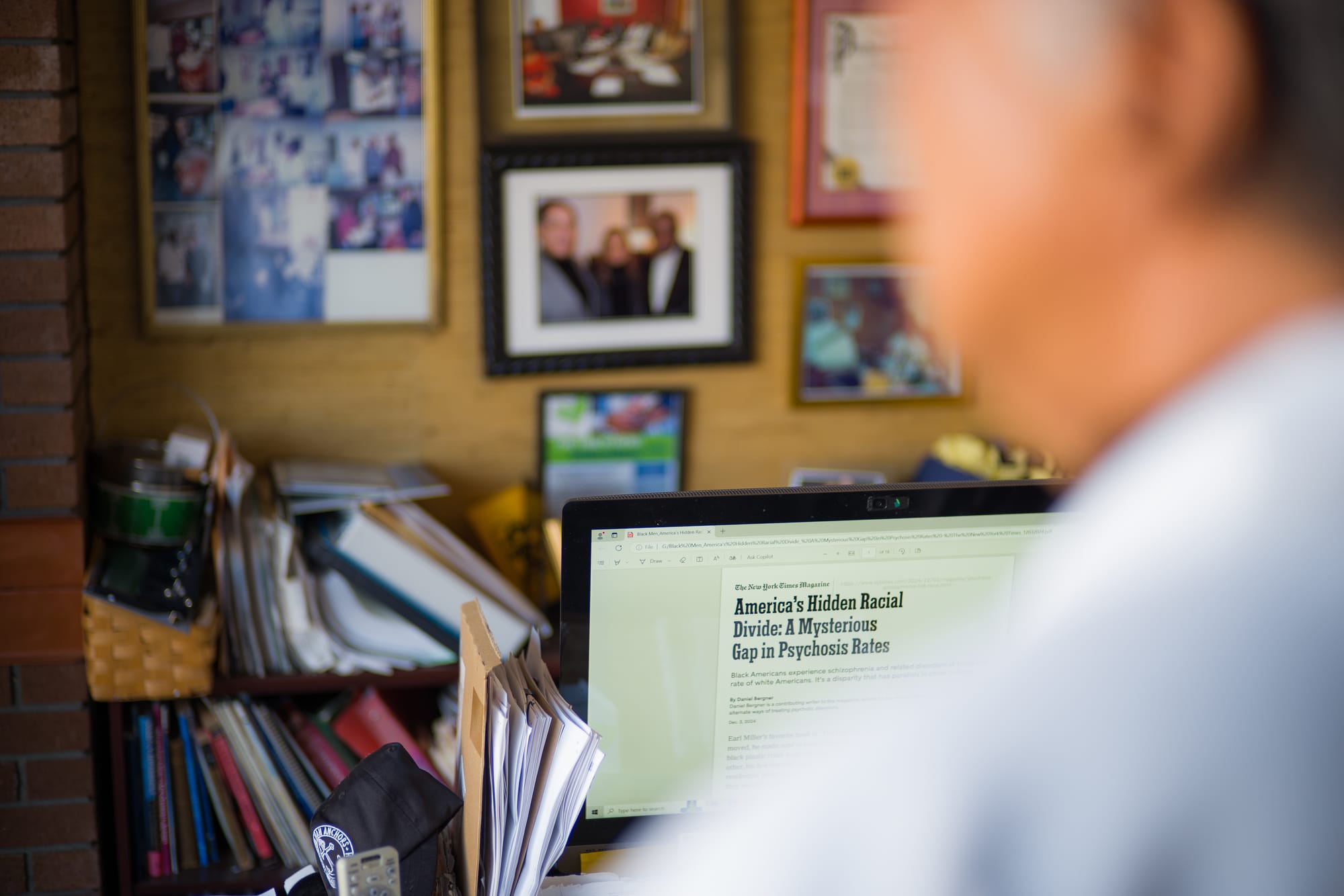 A blurred image of a doctor in the foreground, and an in focus computer screen with an article about the U.S. racial divide.