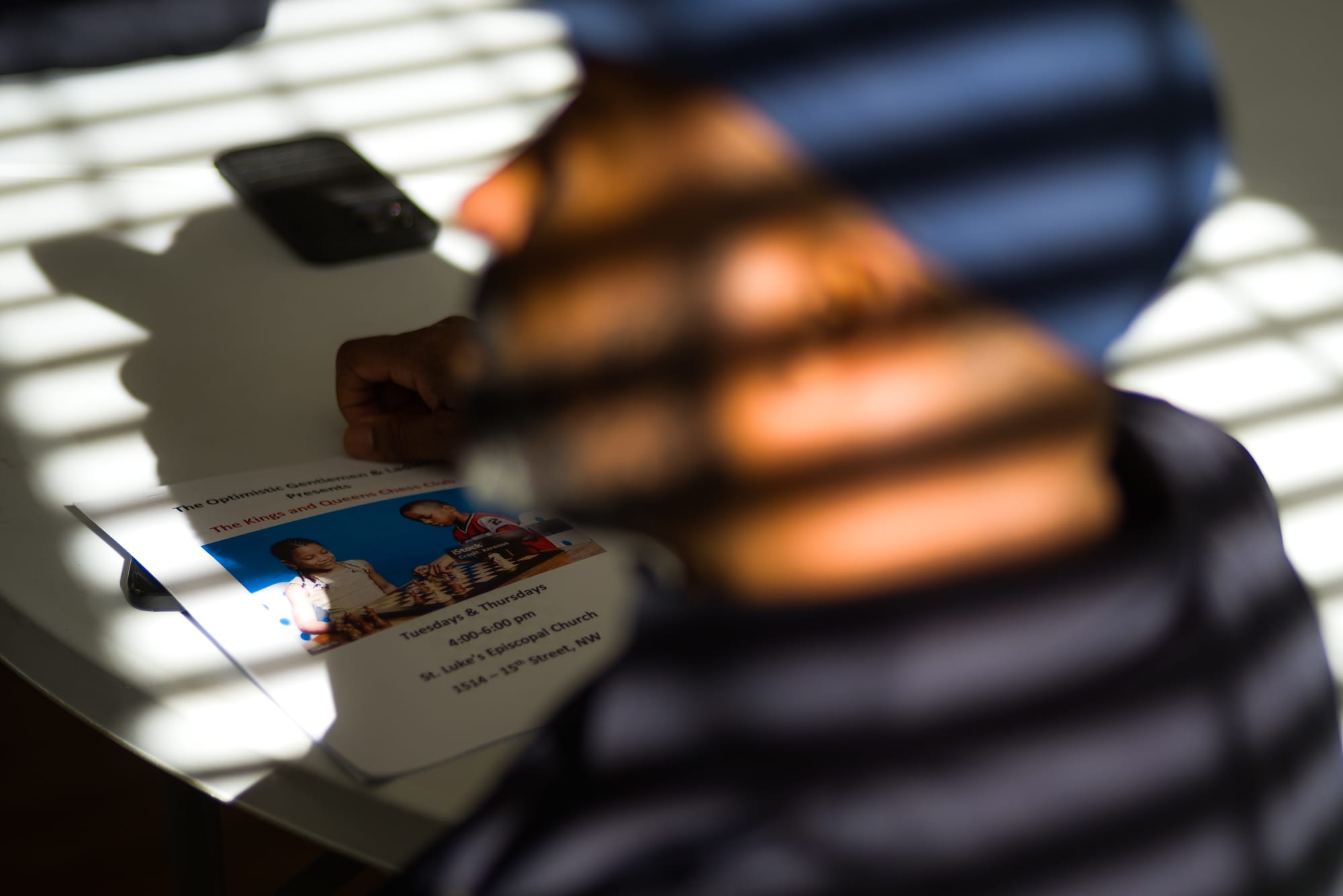 A close up image of a man's face that is blurry and covered in a grid of shadows.