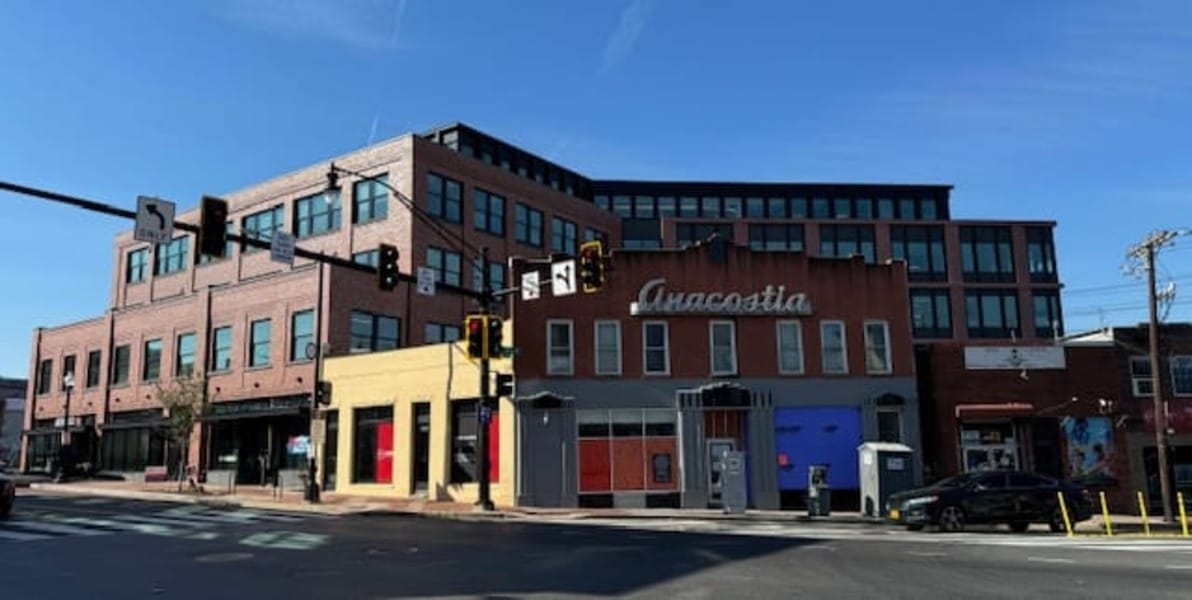 A photo of an intersection with a cluster of buildings, with one on the corner reading "Anacostia."