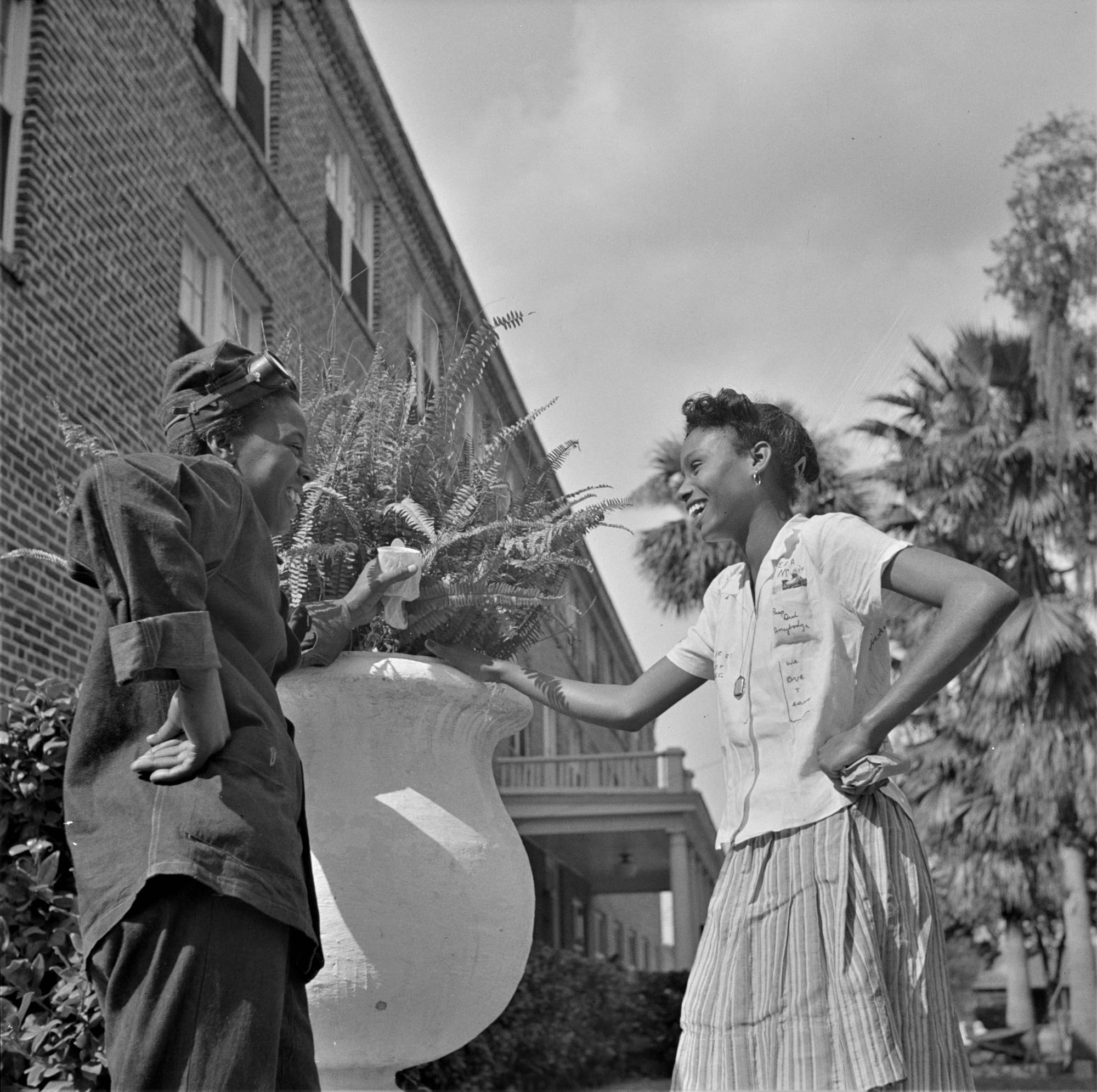 An older black and white photograph of two friends at college chatting.