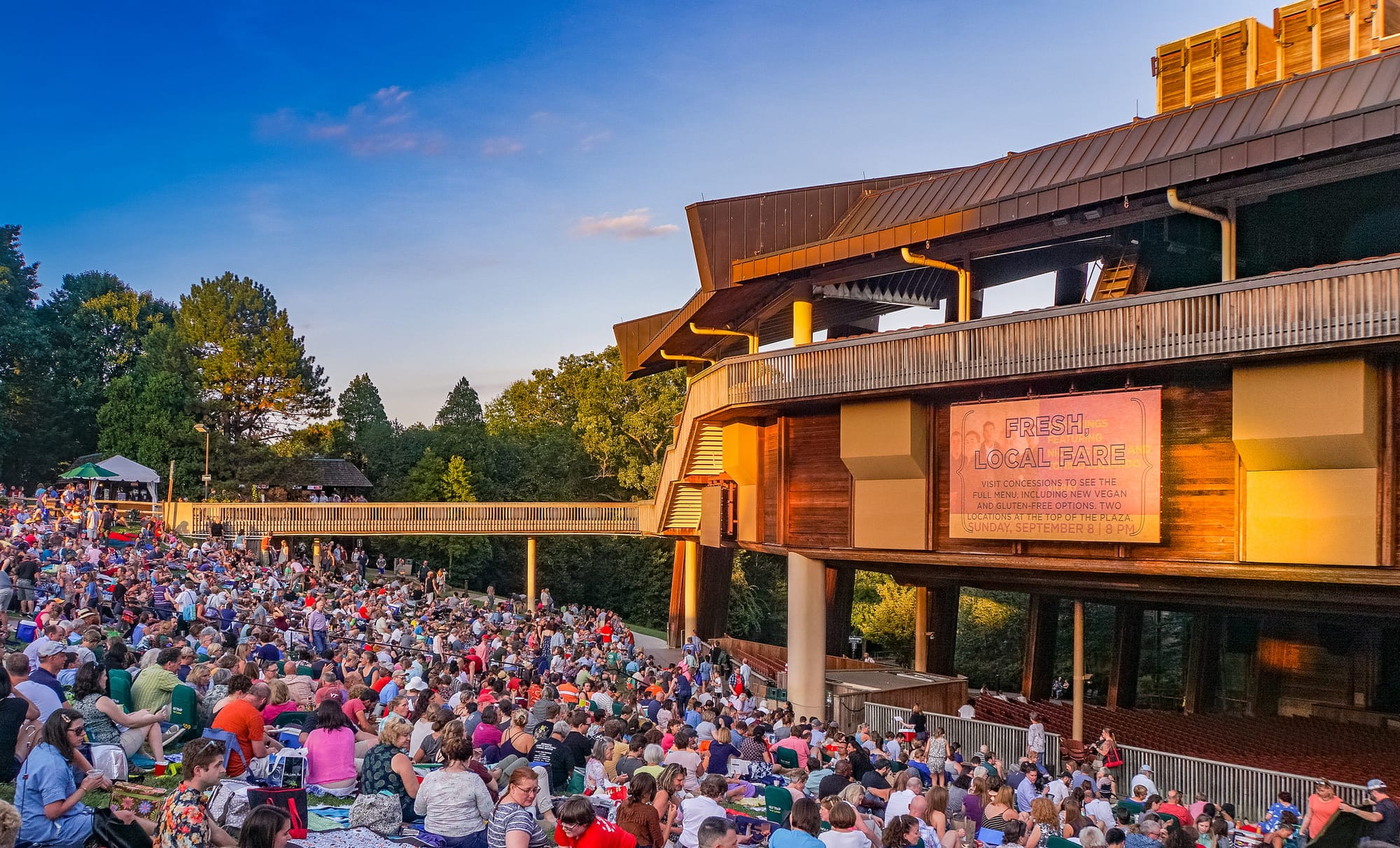 A view of the lawn seating at Wolf Trap. A large crowd is seated for a show.