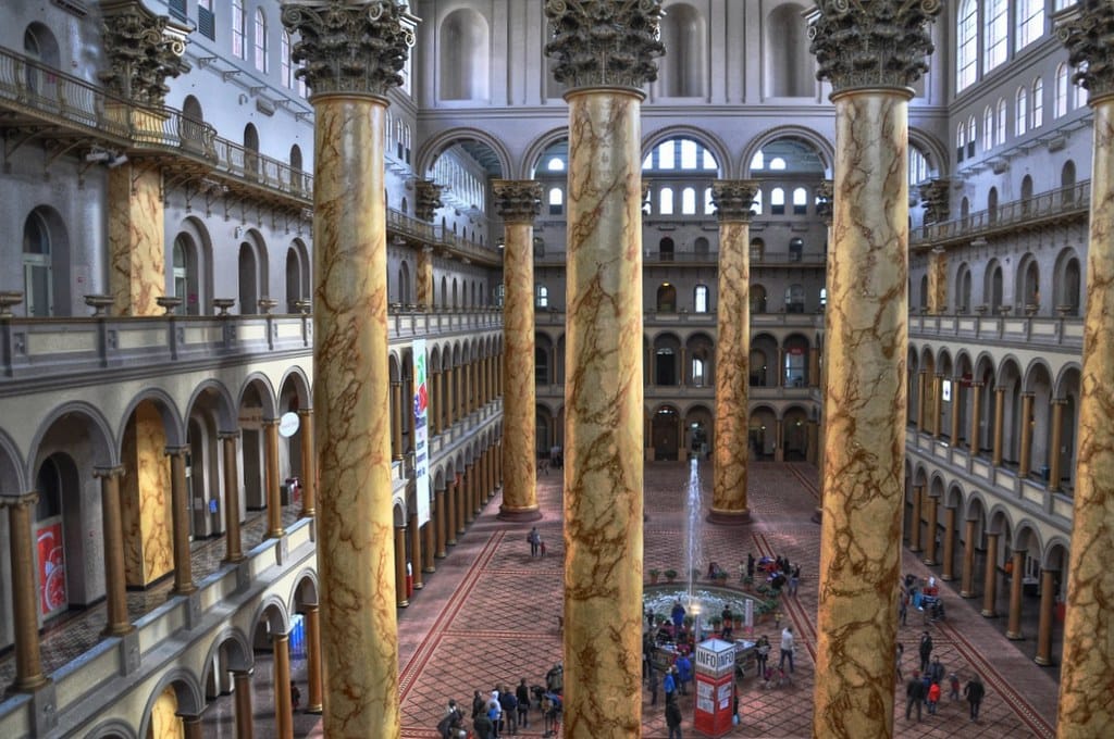 The inside of a large hall with massive marble columns. 