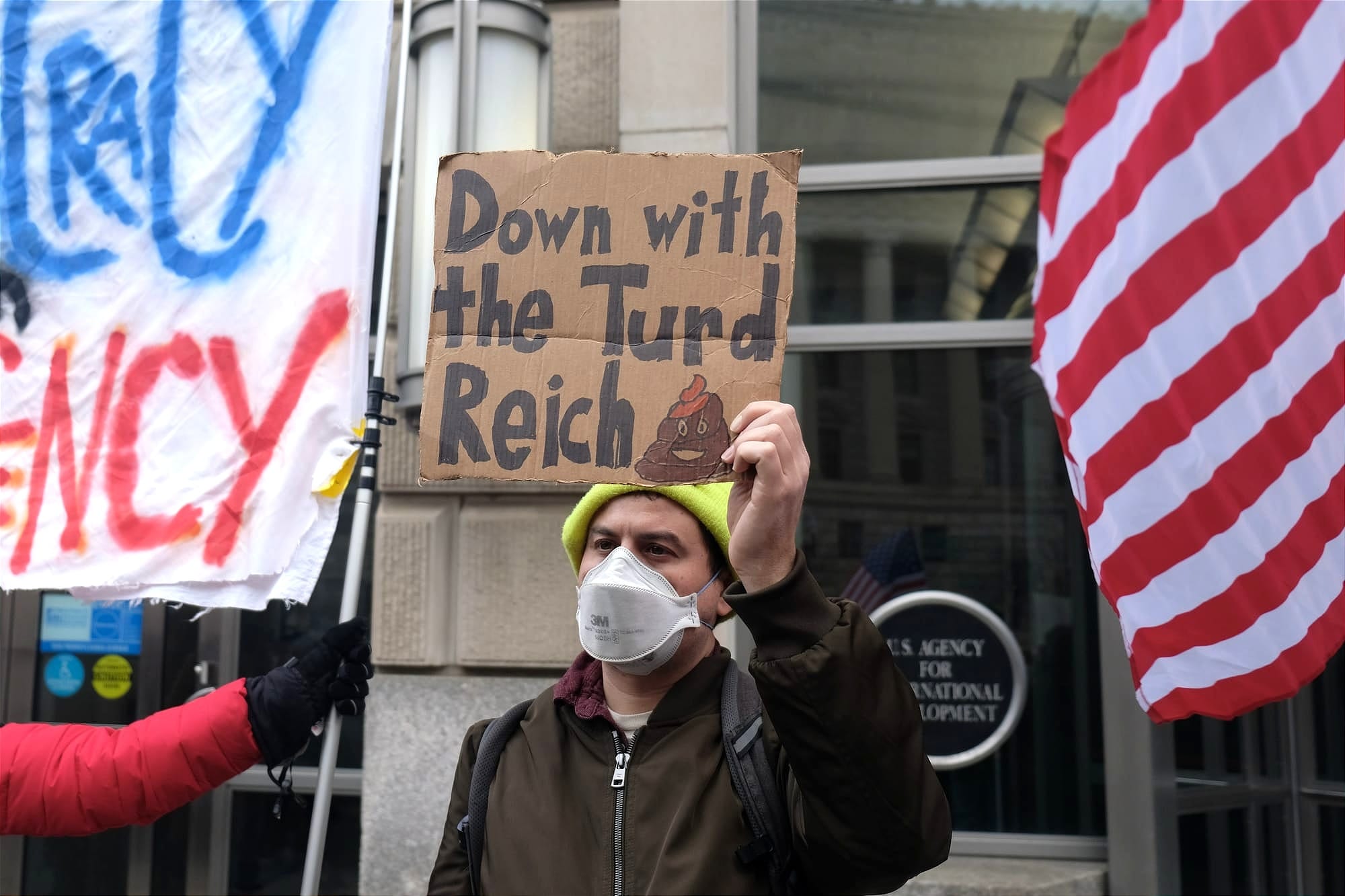 A protestor holding a sign that reads: "Down with the Turd Reich"