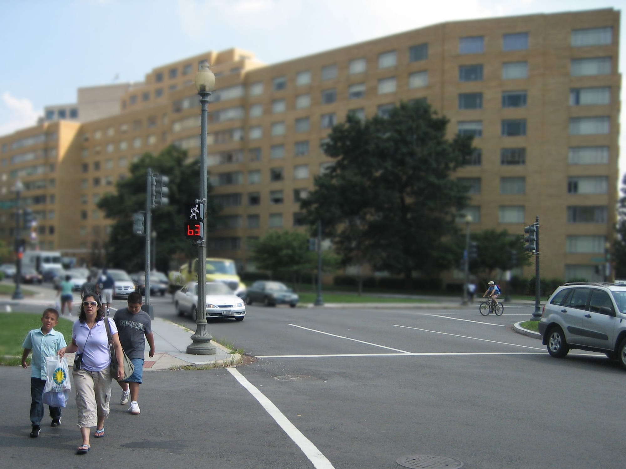 A group of people, one woman and two children, crossing a street in D.C.