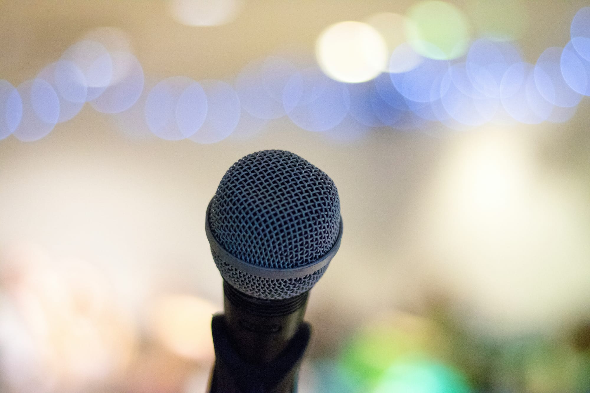 A microphone with blurred lights in the background. 