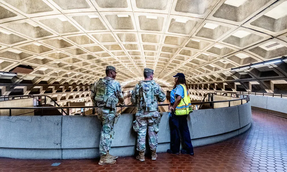 National Guard members speak to a Metro employee in a station.
