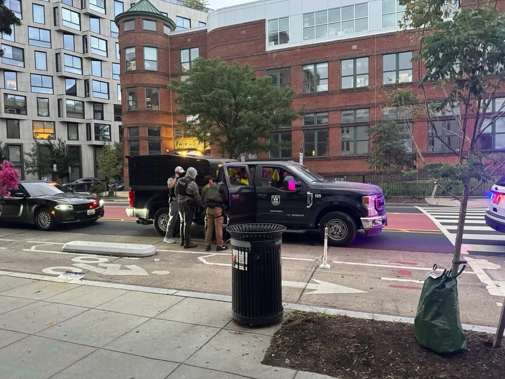 ICE officers huddled around a black truck on Adams Mill Road in Columbia Heights. 