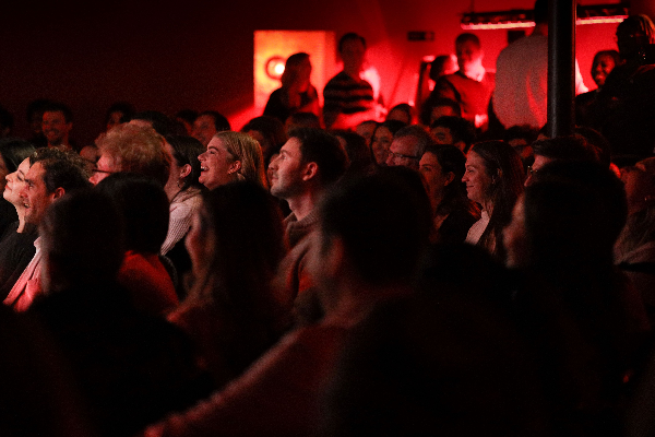 In a darkened room, comedy show attendees do appear to be laughing.