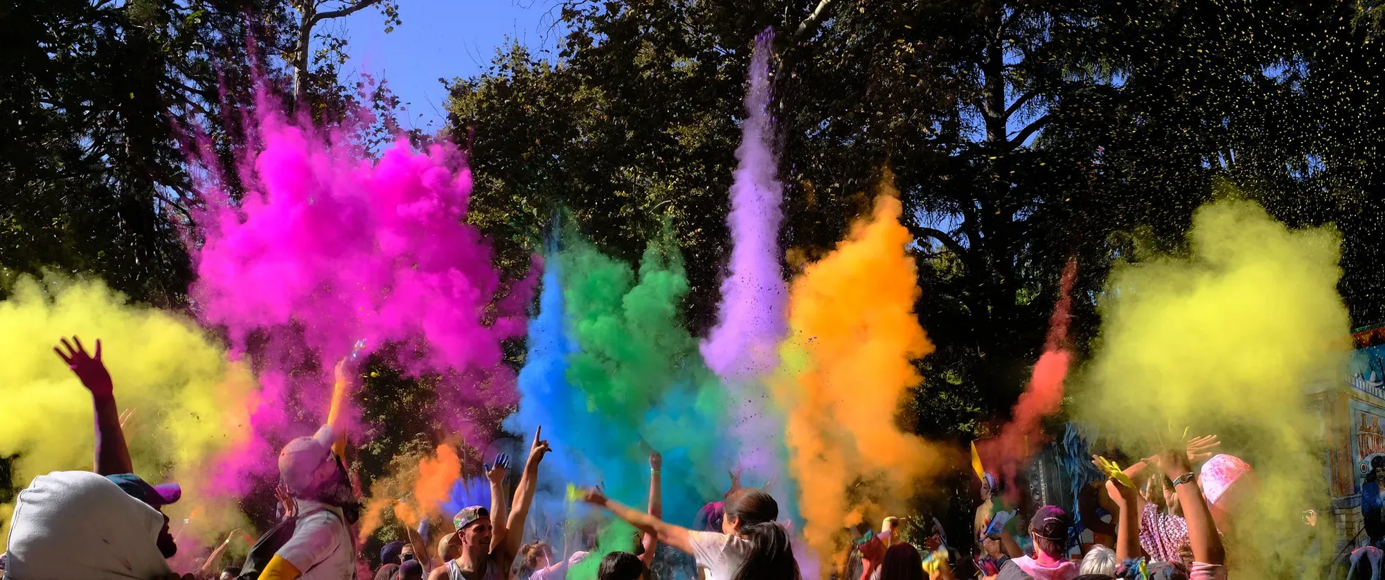 Rainbow bursts explode in the air during a holi celebration.