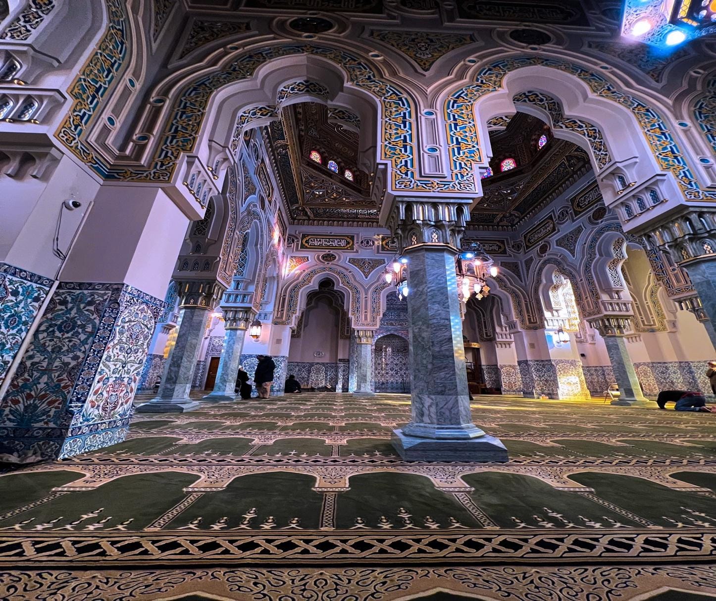 A large ornate room with columns and a green carpet

AI-generated content may be incorrect.