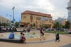 Adults and children scattered at an outdoor plaza surrounded by buildings in Washington D.C.'s Columbia Heights.
