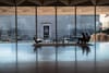 Two women sit in chairs before a wall of windows in the National Gallery of Art in D.C.