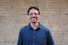 Photo showing Eric from the shoulders up, standing in front of a brick wall.