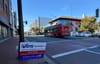 A photograph of a street in Ward 8 with a bus in the background and a sign that says "Vote November 5" in the foreground.