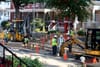 A picture of construction workers digging up lead pipes with large machinery.