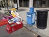 Colorful newspaper boxes in various states of knocked over along a sidewalk in D.C.