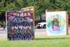 Two murals on a lawn. One says: "All power to the people." The other says: "God is Love and Black Lives Matter."