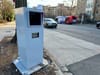 A large traffic camera is posted on a sidewalk along a main residential street in D.C.