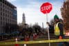 A construction worker holds a stop sign near the demolition of the block. 