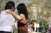 A couple dancing in the park, facing away from the camera.