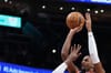 Alexandre Sarr of the Washington Wizards shoots a basketball as a defender guards him.