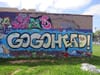 Colorful mur that says GOGOHEAD! with green creature in the background.