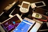 A pile of cellphones from different eras