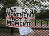 A sign saying This Is a Movement Not a Moment hanging on a gate in Washington, D.C.
