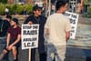 Protesters in Columbia Heights hold signs that read "Stop the raids, abolish ICE"