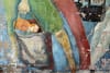 chipped mural of people carrying grocery bags.