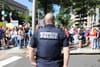 A uniformed D.C. police officer standing in front of a protest, with his back to the camera.