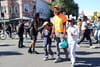 A father holding the hands of his two daughters walks down 14th street in a protest.