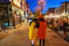 People dressed as mustard and ketchup bottles huddle on a D.C. sidewalk, next to a streatery.