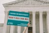 A person holds up a sign in front of the Supreme Court that reads "I oppose the death penalty. Don't kill for me!"