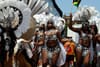 Women adorned in festive carnival wear parading in the street. 
