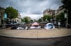 Three tents in D.C.'s Dupont Circle under a cloudy sky.