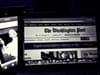 A black and white photograph of a laptop screen with The Washington Post homepage, and Jeff Bezos in the background.