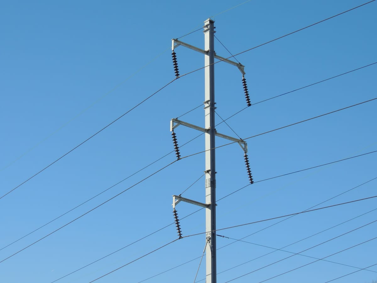 Electricity lines crisscross in the sky. 