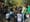 Un grupo de bomberos y rescatistas habla ante un grupo de periodistas que sostienen micrófonos y cámaras. 