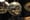 A silver disco ball hangs next to a mirror, reflecting gold light. 