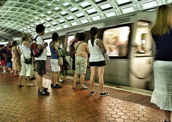 People wait for Metro train to stop.