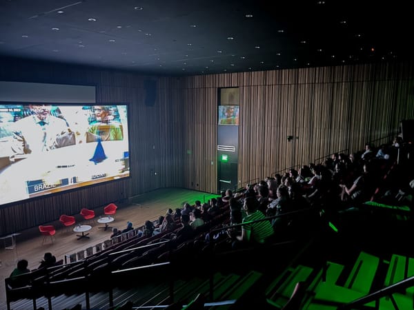 A photograph of a movie theater during a screening at the Palestinian Film Festival packed with attendees.