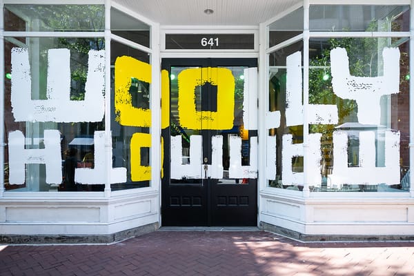 Photo of a theater with Woolly written in big white and yellow letters and mammoth written underneath, upside down.