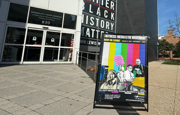 The door to the Reginald F. Lewis Museum in Baltimore, with a placard for 'Witness: Media & The Movement' 