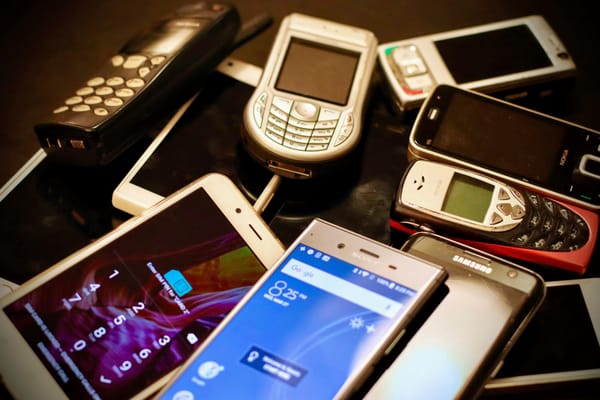 A pile of cellphones from different eras